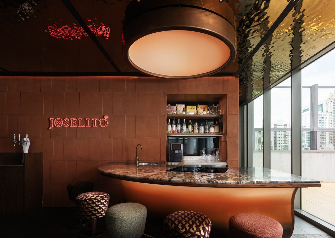 The curved copper-and-marble bar with its back-bar spirits shelf