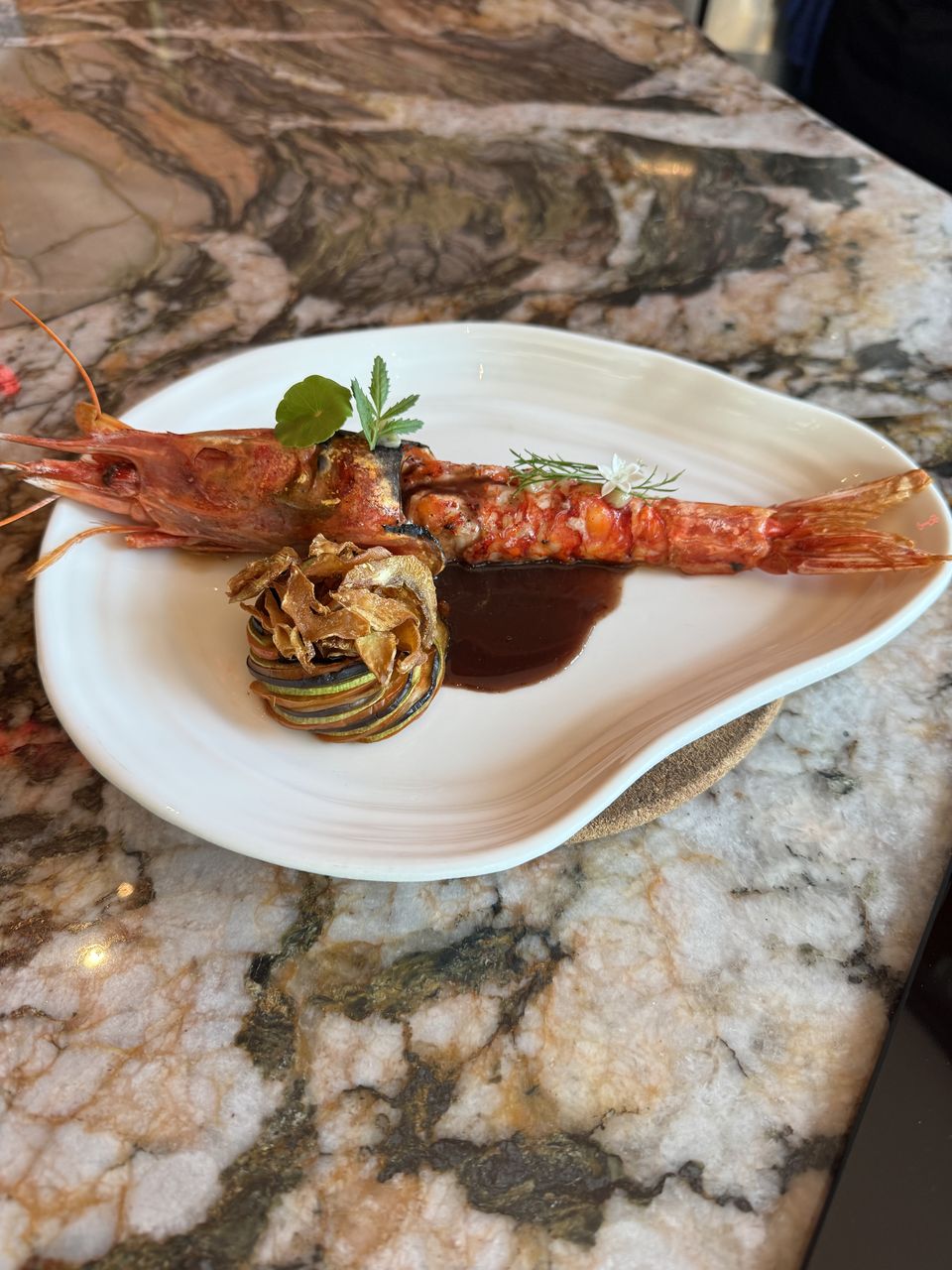 Whole scarlet carabinero prawn, split lengthwise and charcoal-grilled, in a dark sauce