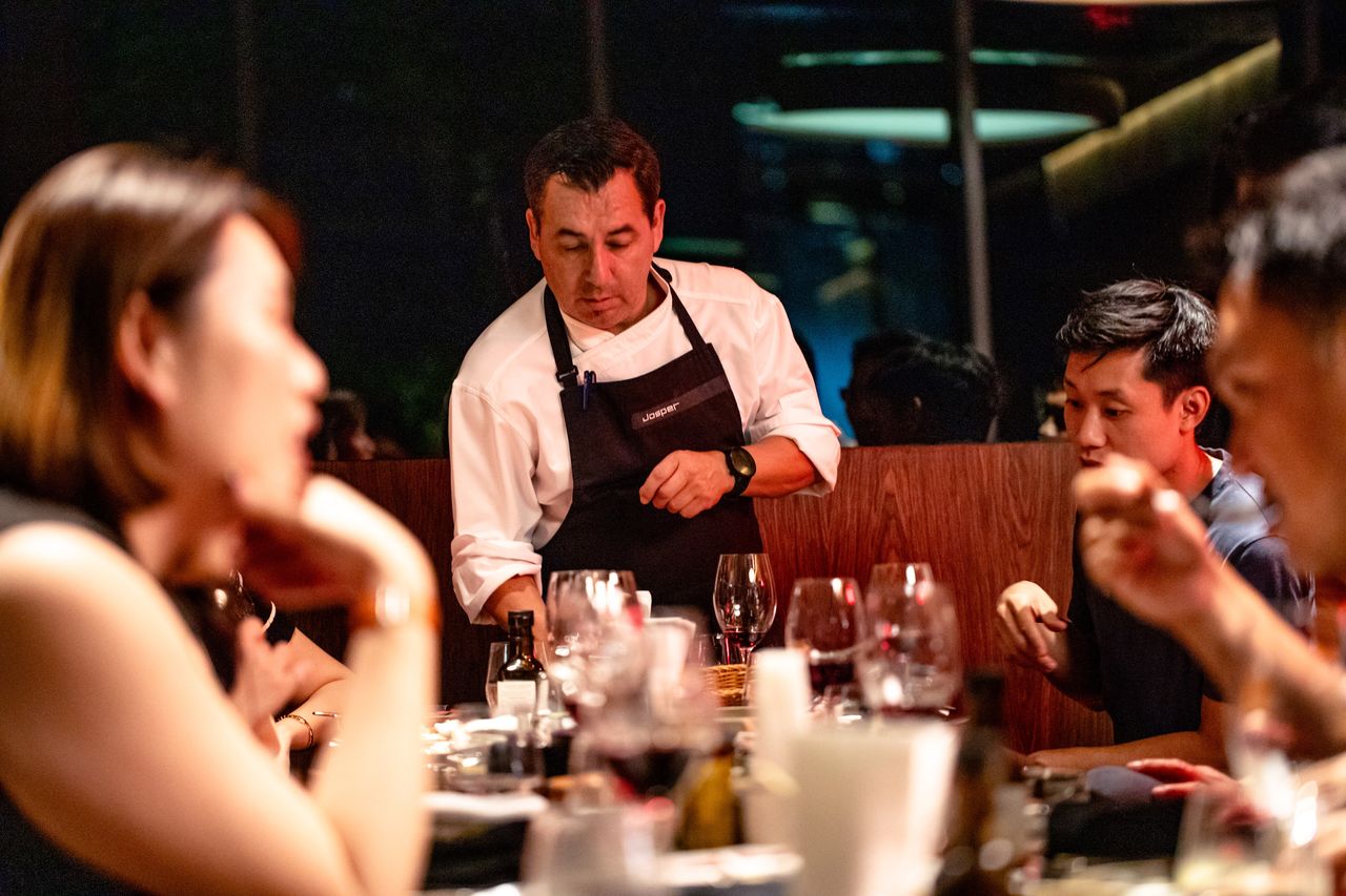 Chef Sandro Aguilera serving a course at a guest's table