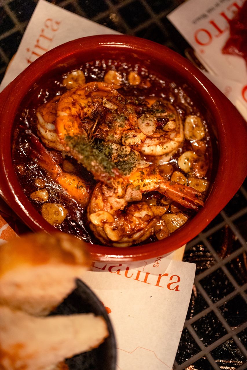 Gambas al ajillo — prawns confited in olive oil with sliced garlic, in a terracotta cazuela
